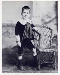 Family photograph of young Harry standing beside a chair